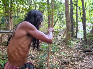 Vedda de Sri Lanka apuntando con el arco en el bosque