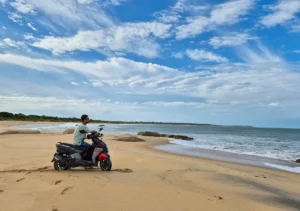 yo con la scooter en la arena de la playa de Okanda