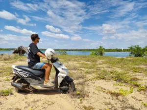 Yo con la moto mirando al faro de Batticaloa